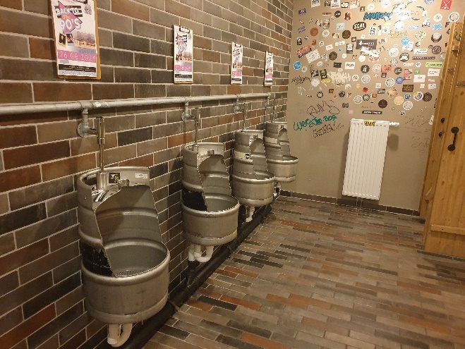 A bathroom with several urinals

Description automatically generated